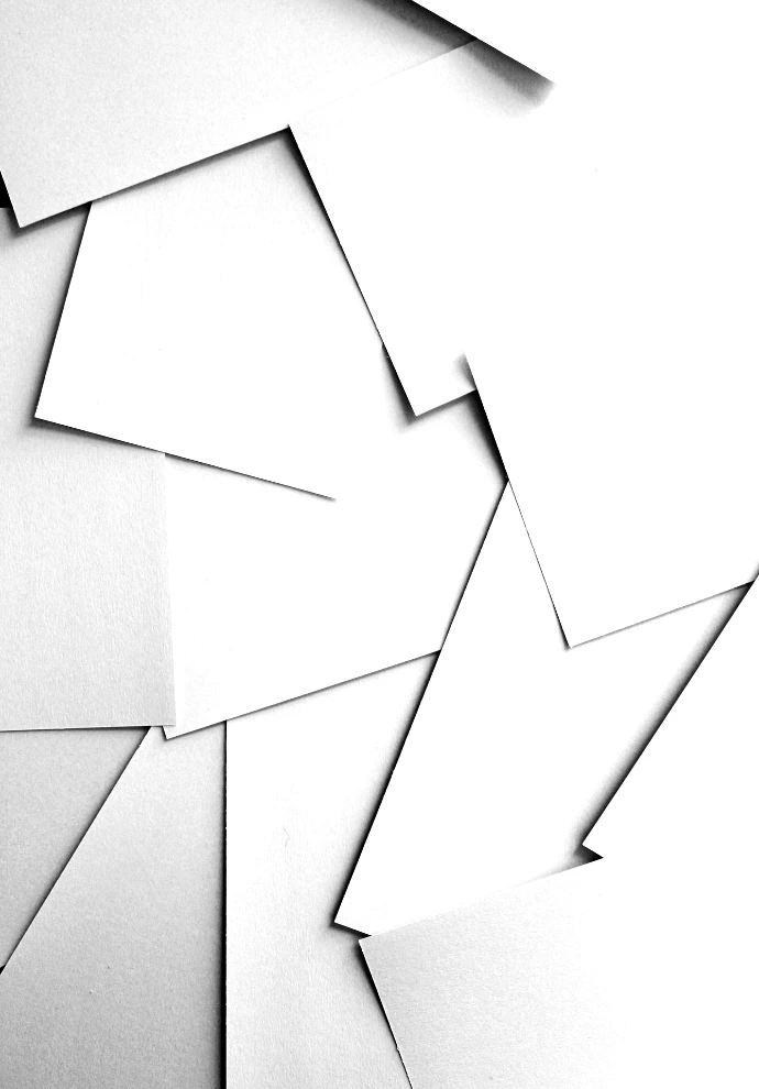 Scattered sheets of white paper covering the entire frame